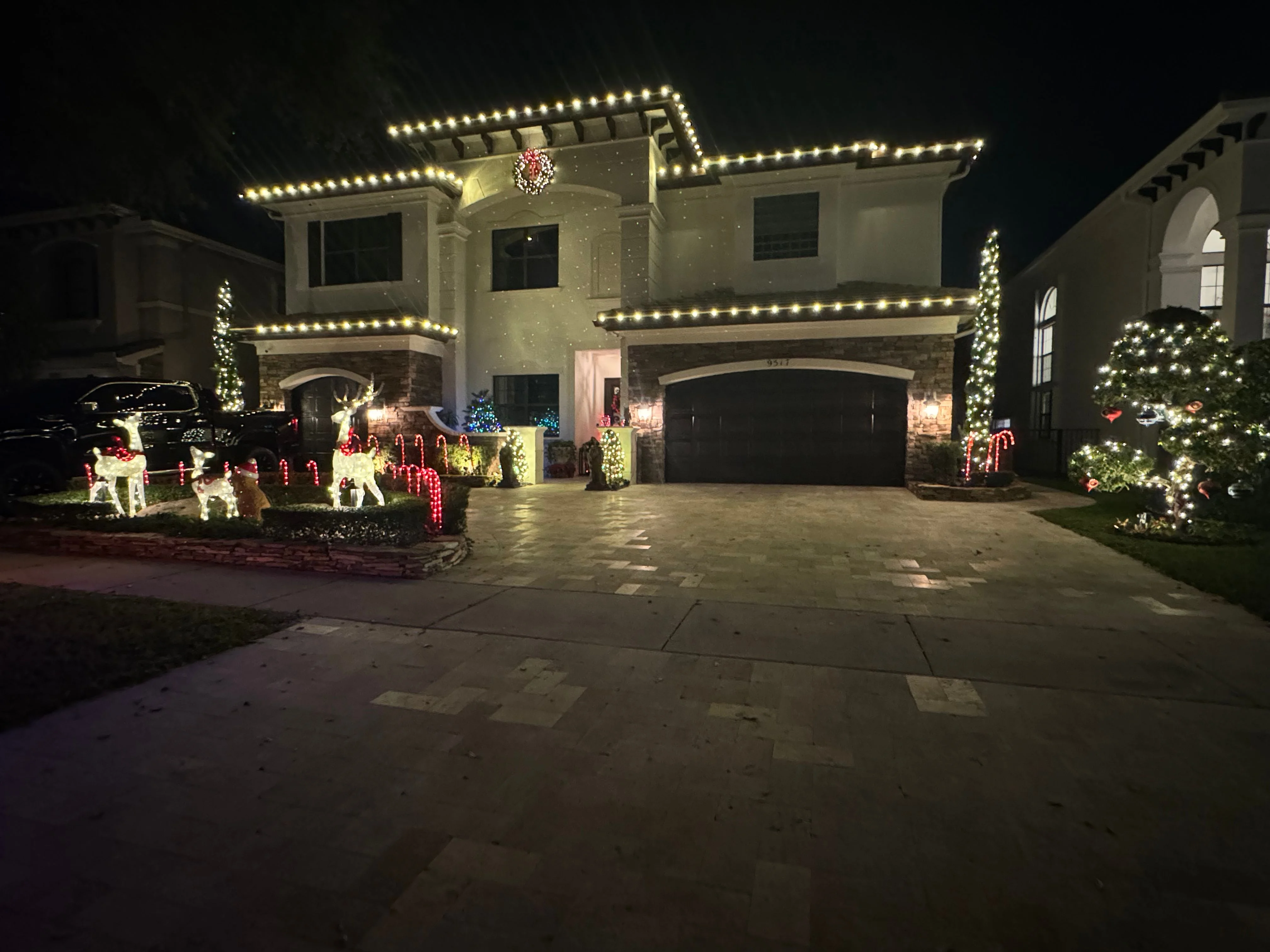 Festive Christmas house display with roofline lights and decorative yard elements