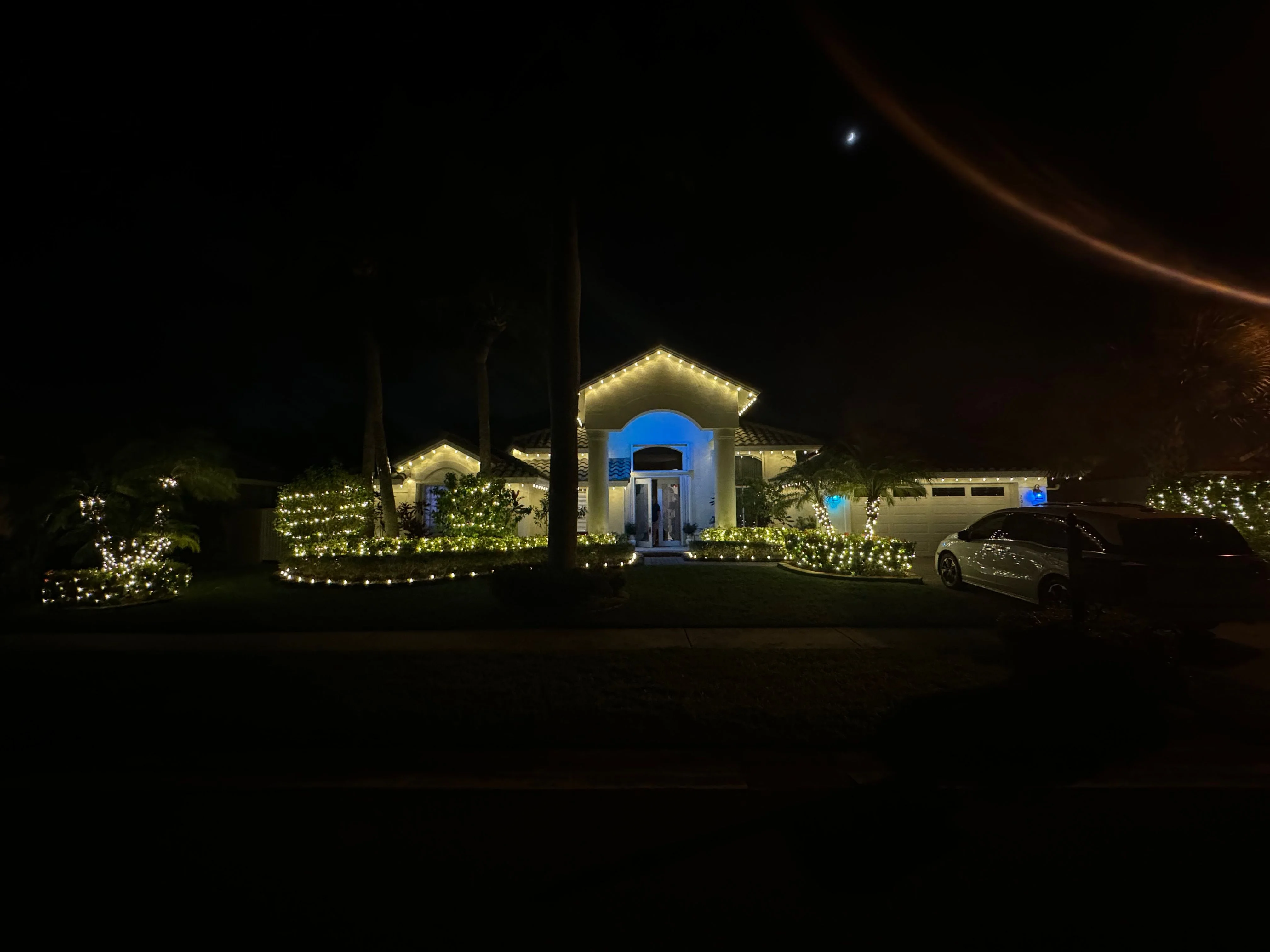 Elegant house with warm white LED lights outlining roofline and landscaping