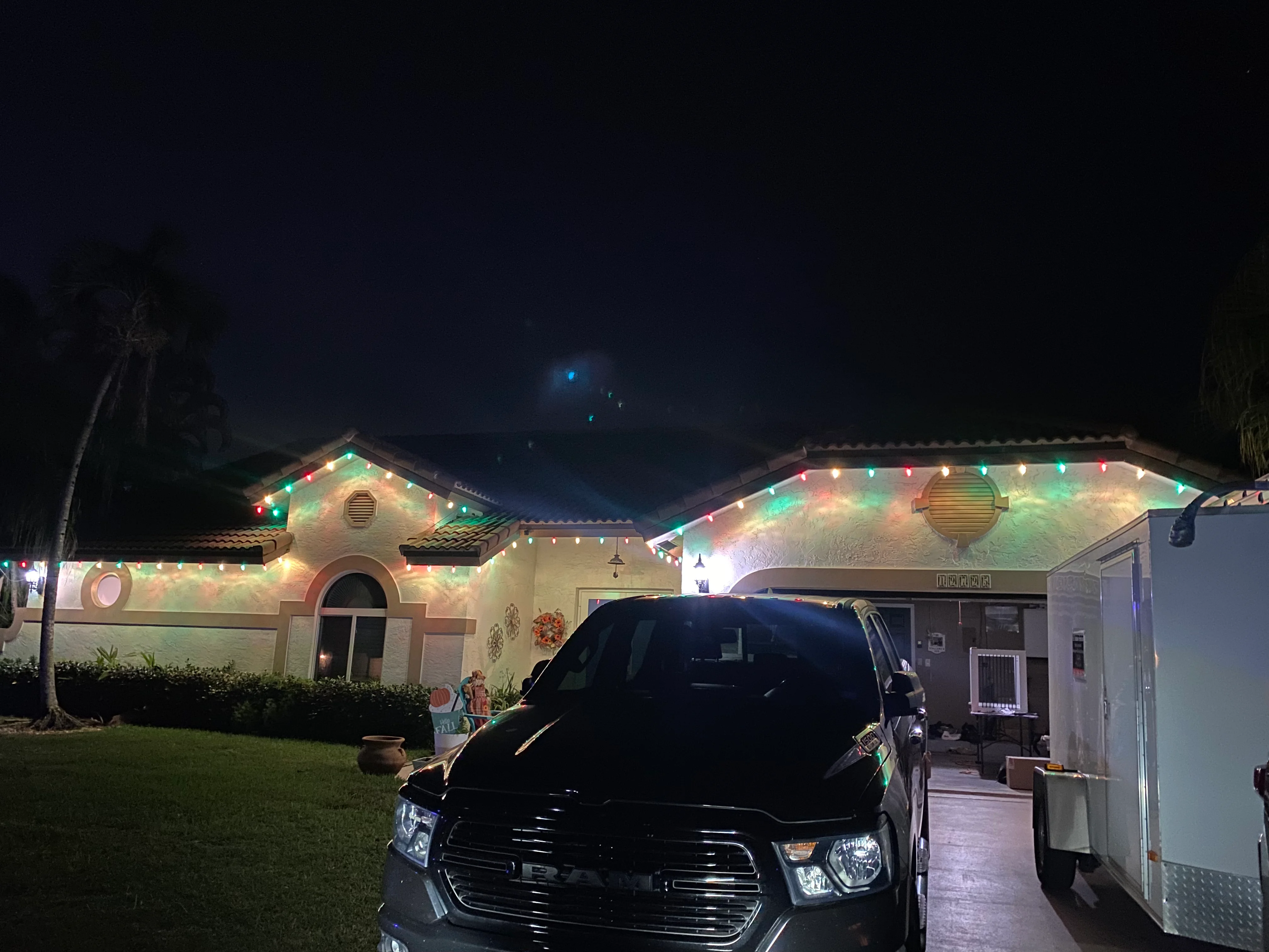 House with festive multicolor string lights on roofline creating vibrant Christmas display
